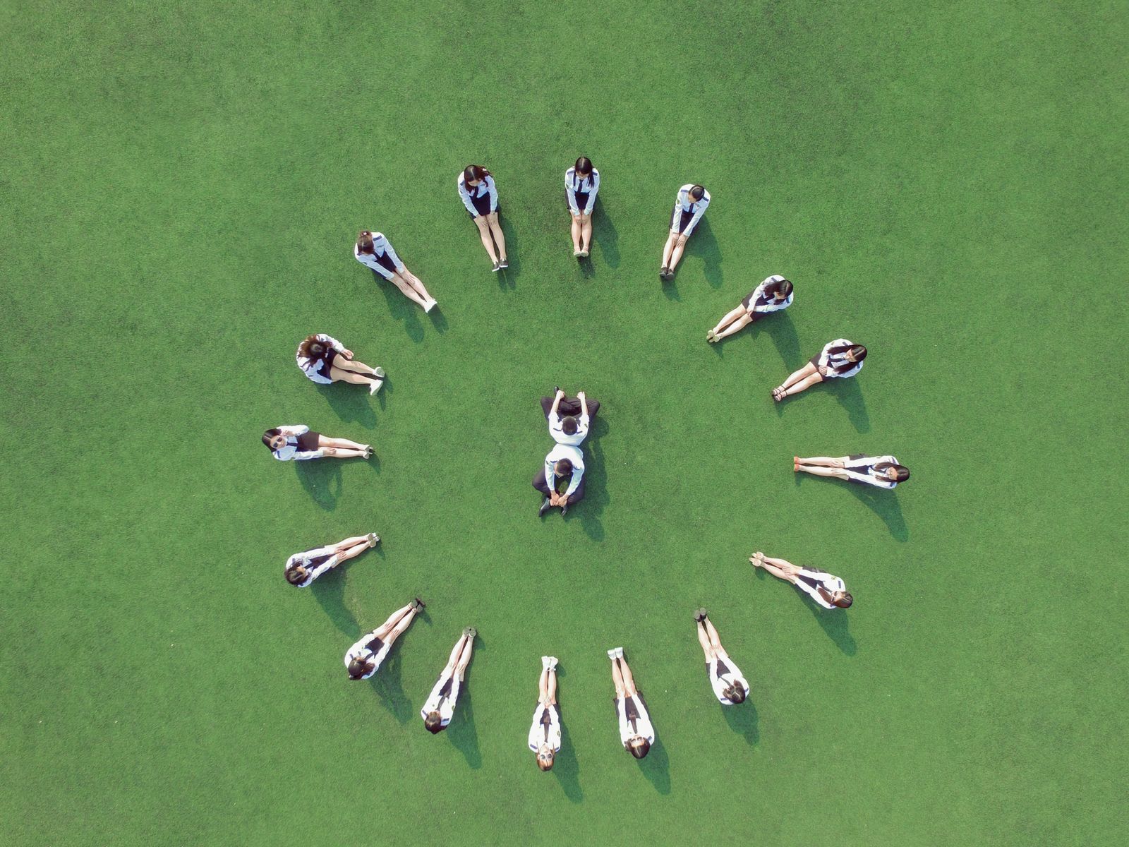 Aerial view of students forming a circle on a green field