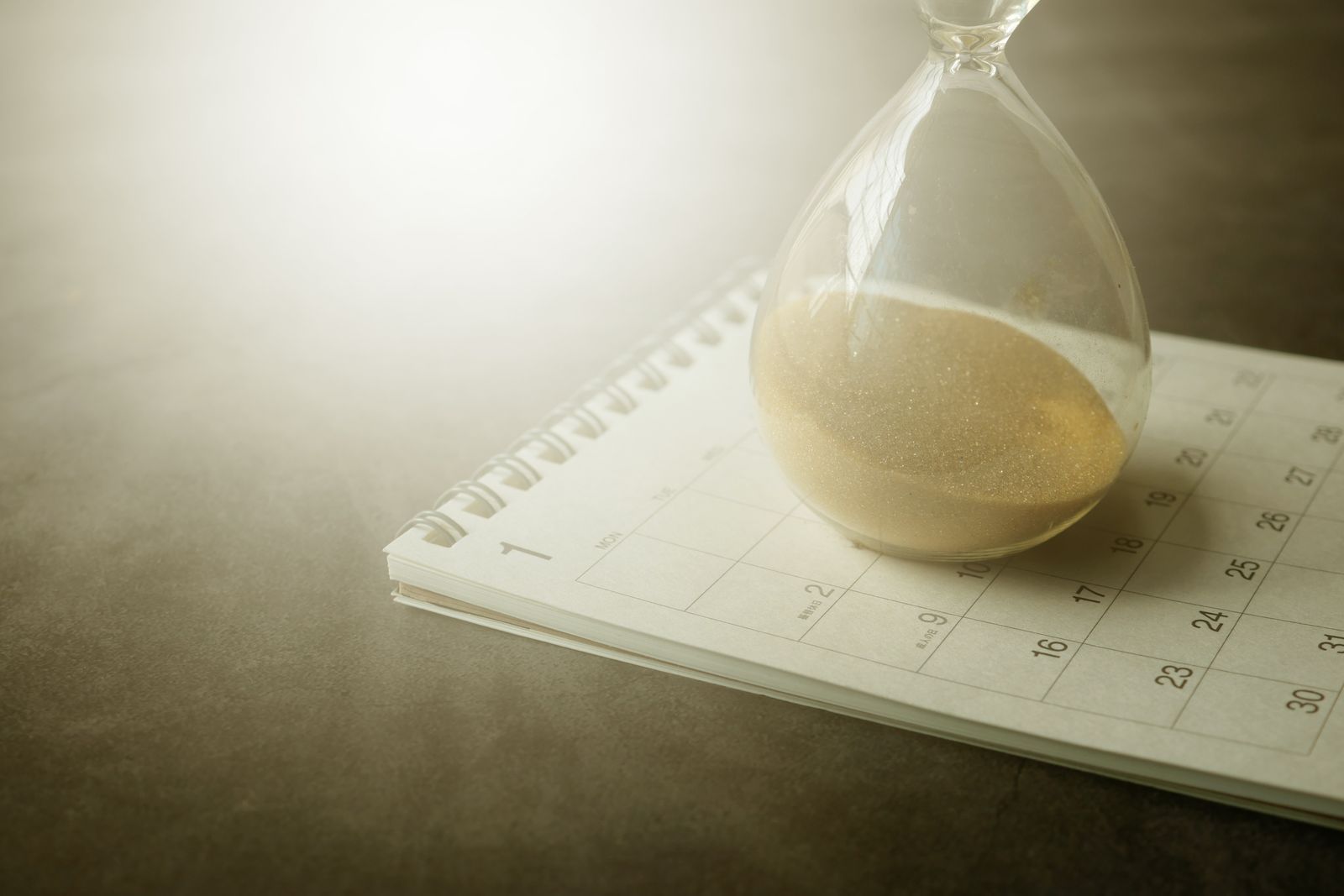 Hourglass resting on a calendar, symbolising an application deadline
